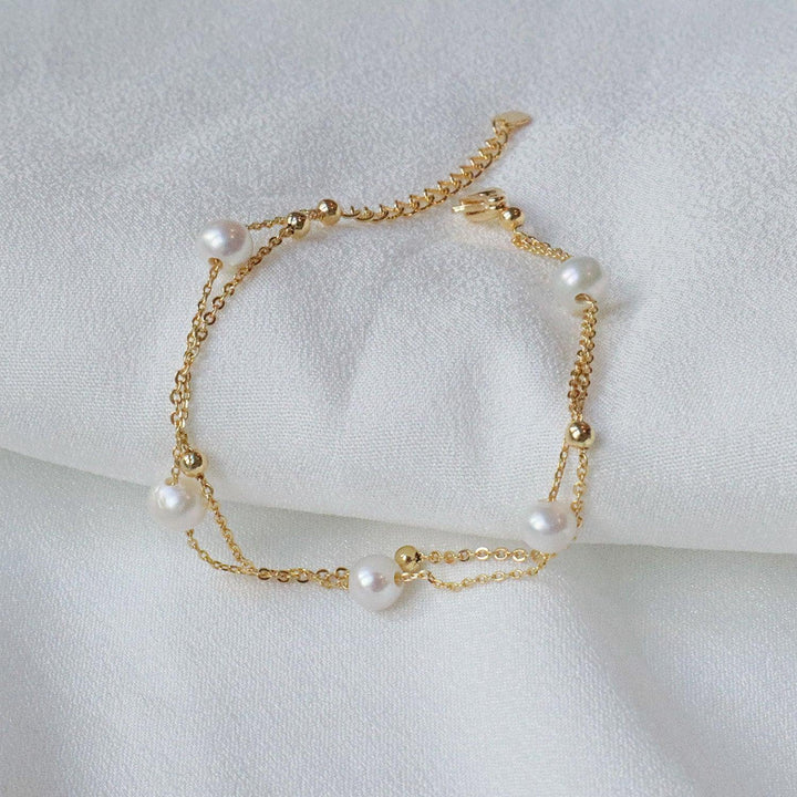 Pearlpals double chain pearl bracelet two delicate chains - one adorned with golden beads, and the other with five lustrous pearls