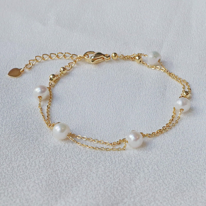 Pearlpals double chain pearl bracelet two delicate chains - one adorned with golden beads, and the other with five lustrous pearls