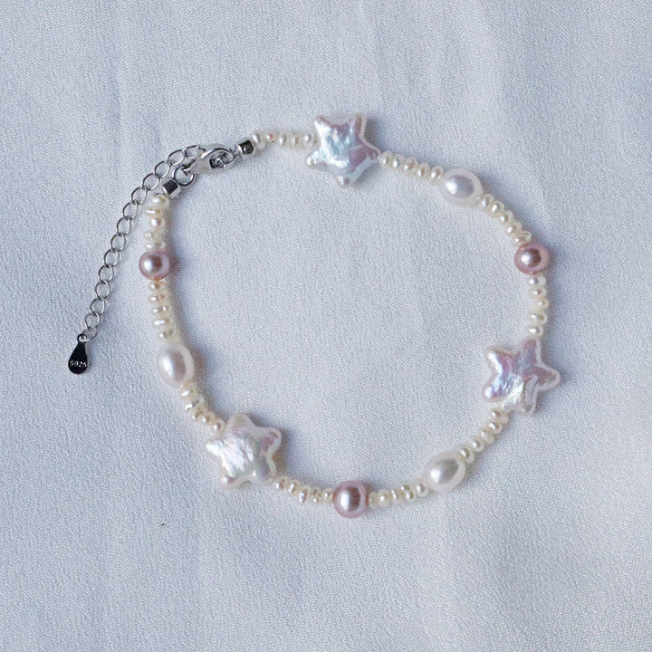 Pearlpals Pearl Bracelet, meticulously crafted from a combination of white pearls, purple pearls, star-shaped baroque pearls, and flat pearls, all fashioned from sterling silver.