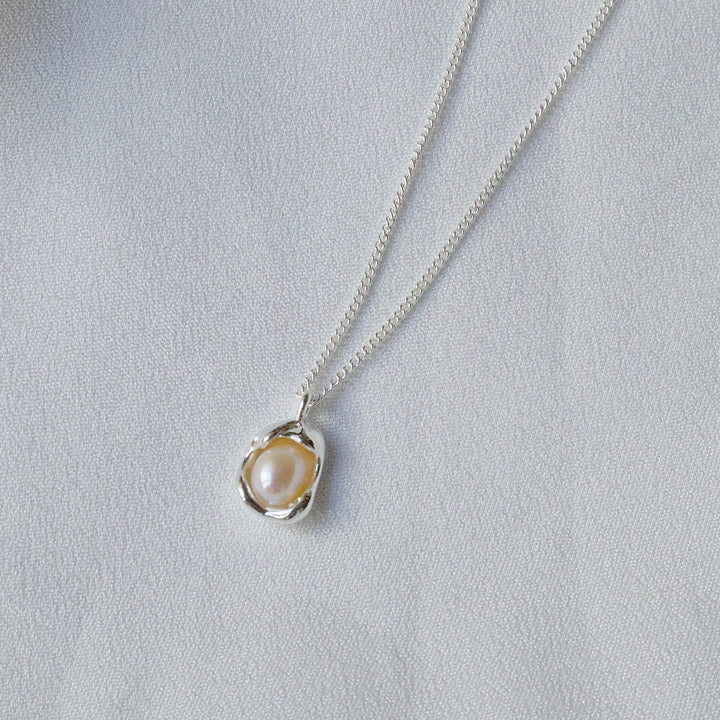 Pearlpals pearl pendant necklace features a half-concealed pearl nestled within an egg-shaped pendant, crafted from sterling silver.