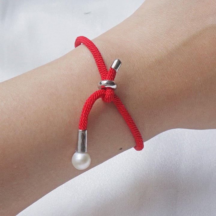 Pearlpals The 7mm freshwater Pearl Bracelet features a vibrant red rope and adjustable knot closure