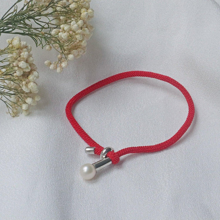 Pearlpals The 7mm freshwater Pearl Bracelet features a vibrant red rope and adjustable knot closure