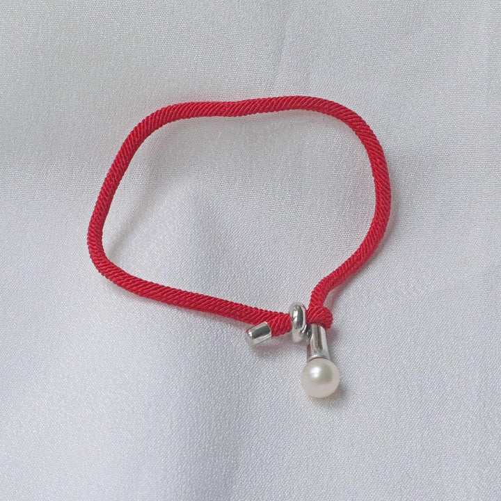 Pearlpals The 7mm freshwater Pearl Bracelet features a vibrant red rope and adjustable knot closure