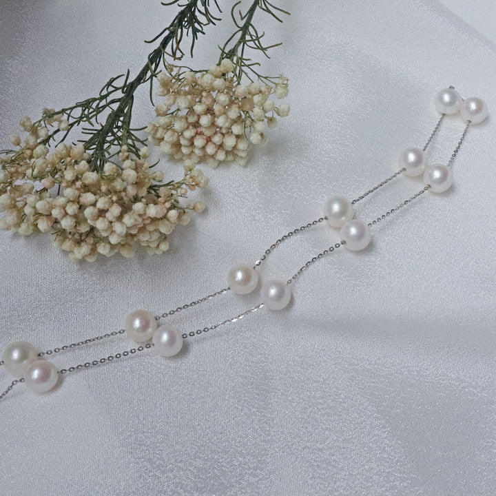 A delicate necklace featuring 7mm AA-grade pearls evenly spaced along a fine sterling silver chain