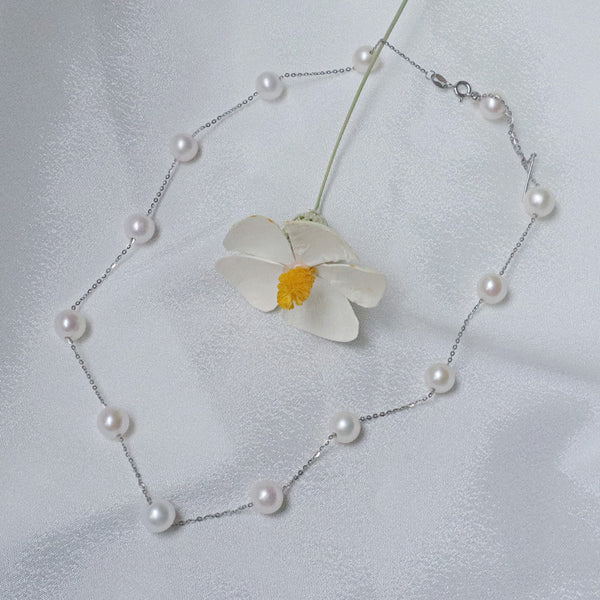 A delicate necklace featuring 7mm AA-grade pearls evenly spaced along a fine sterling silver chain