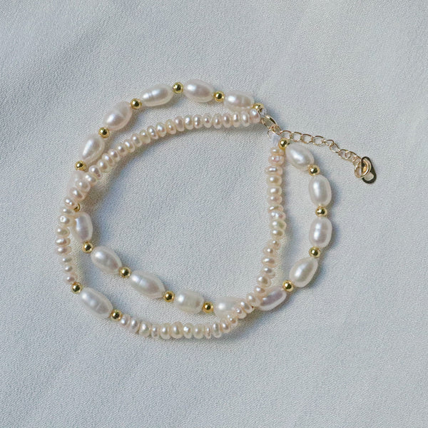 Pearlpals A gold-plated bracelet featuring two layers of pearls, combining round and oval shapes, with delicate gold beads in between