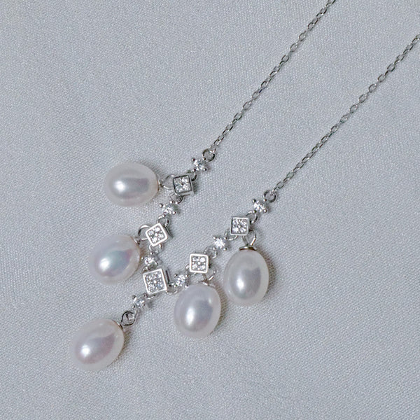 A sterling silver necklace featuring 8mm teardrop pearls and sparkling accents