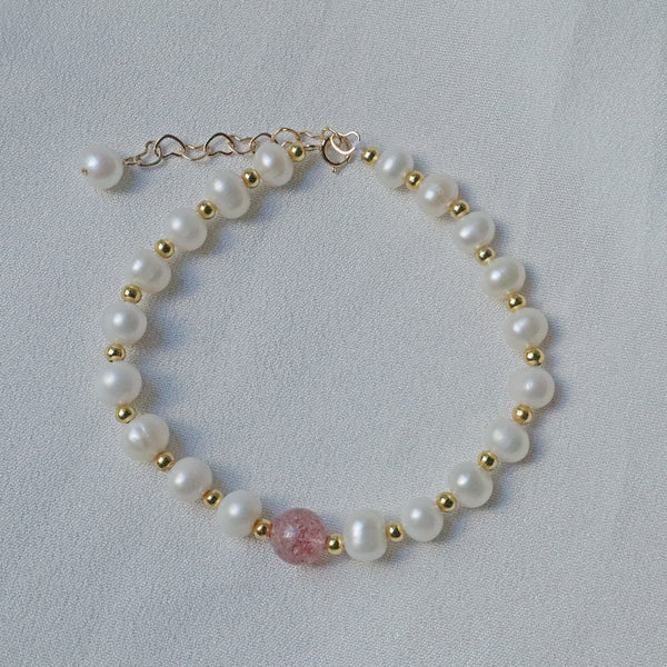 PearlpalsA gold-plated bracelet with pearls and gold beads, featuring a central strawberry quartz bead