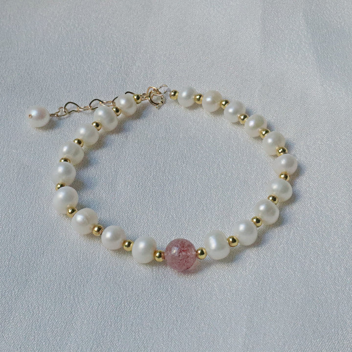 PearlpalsA gold-plated bracelet with pearls and gold beads, featuring a central strawberry quartz bead