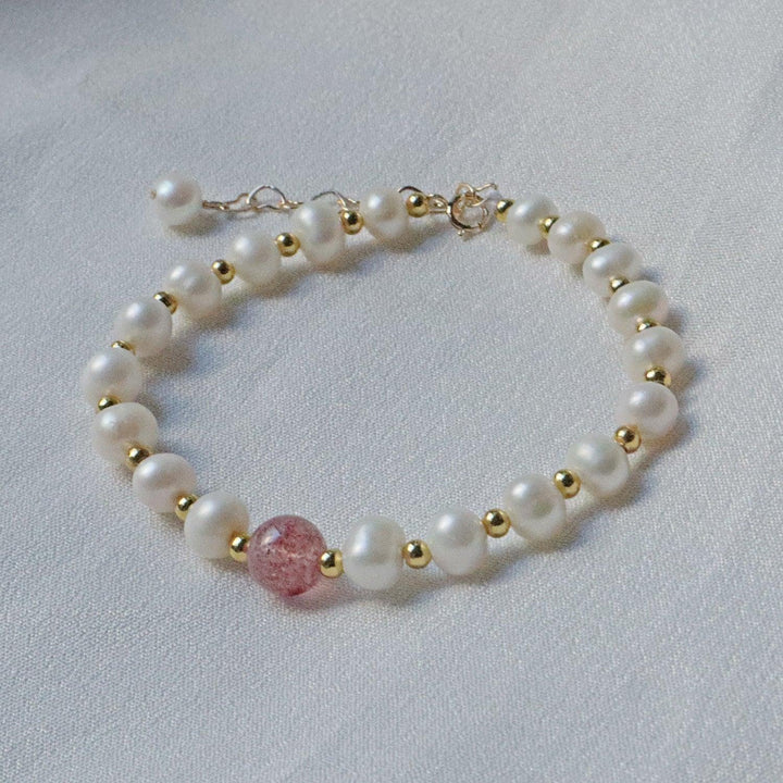 PearlpalsA gold-plated bracelet with pearls and gold beads, featuring a central strawberry quartz bead