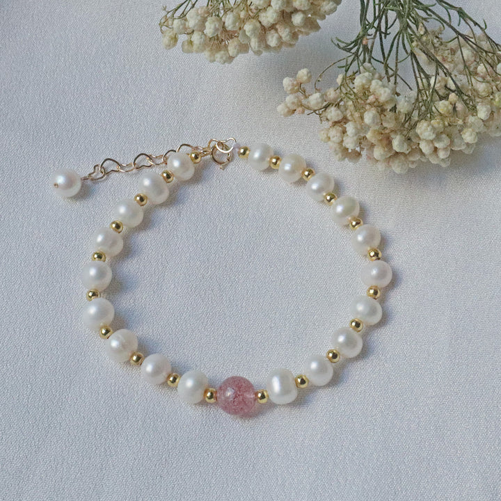 PearlpalsA gold-plated bracelet with pearls and gold beads, featuring a central strawberry quartz bead