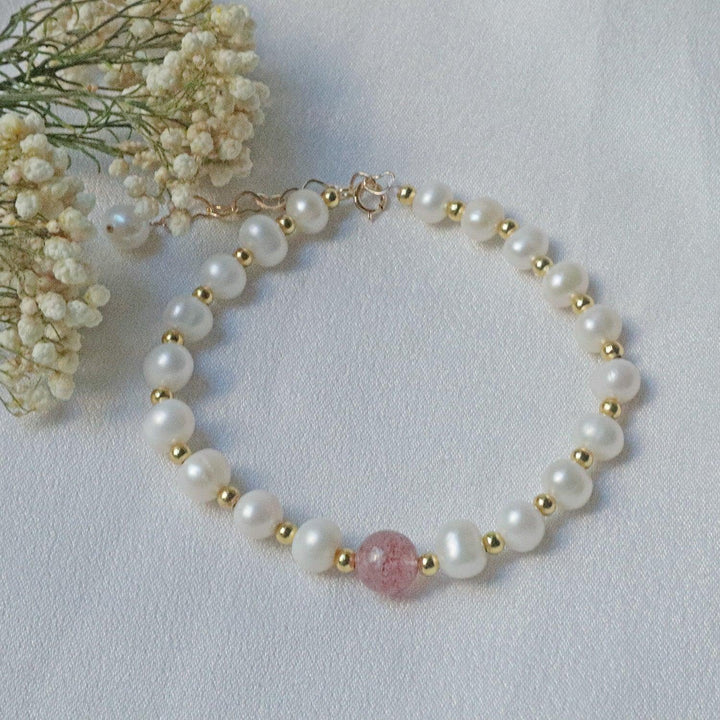 PearlpalsA gold-plated bracelet with pearls and gold beads, featuring a central strawberry quartz bead