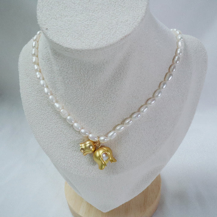 Gold-plated pearl necklace with two gold lily of the valley charms, each containing a pearl